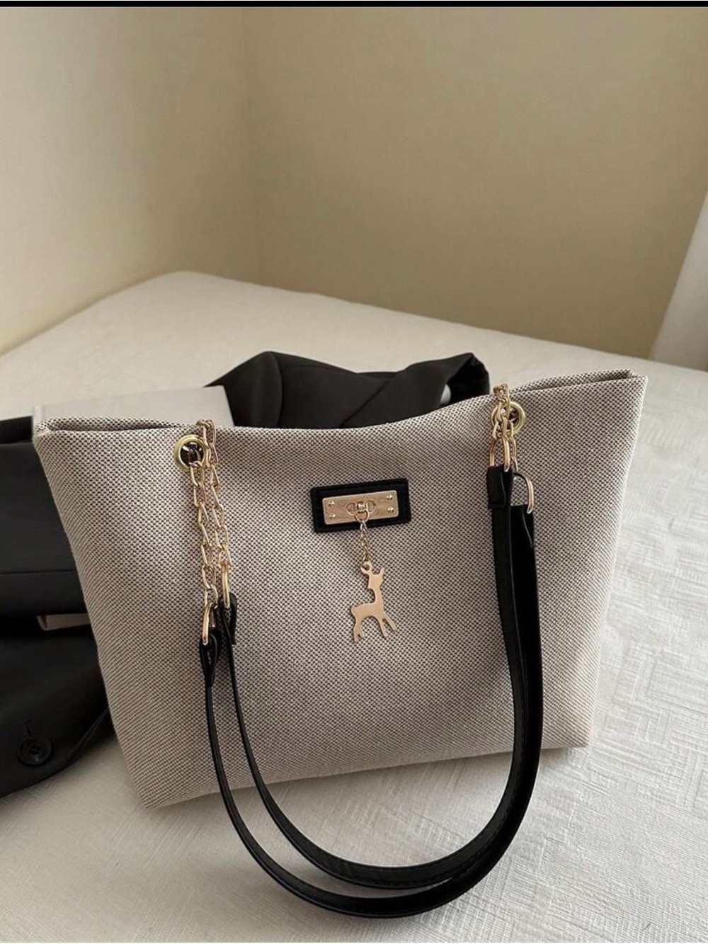 Elegant Beige Canvas Tote with Black Handles and Gold Accents